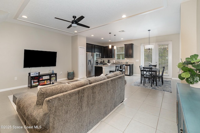 living room with sink, a textured ceiling, ceiling fan, and light tile patterned flooring