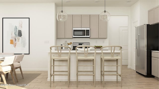 kitchen featuring decorative light fixtures, gray cabinets, a breakfast bar, and appliances with stainless steel finishes