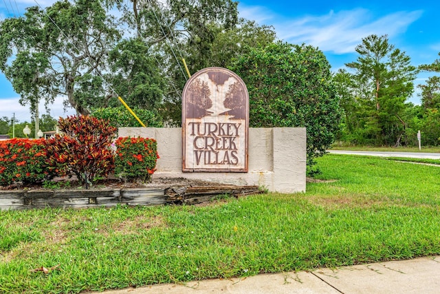 community sign featuring a lawn