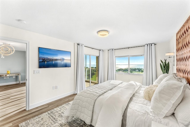 bedroom with access to outside and light hardwood / wood-style floors