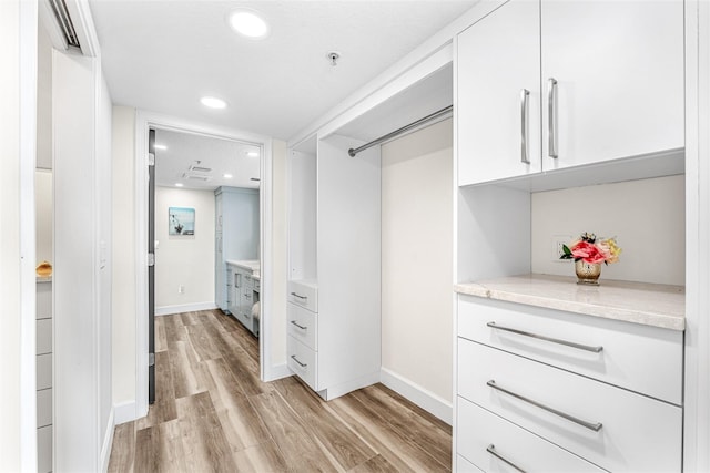 spacious closet featuring light hardwood / wood-style floors