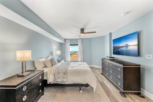 bedroom featuring a textured ceiling, ceiling fan, and light hardwood / wood-style flooring