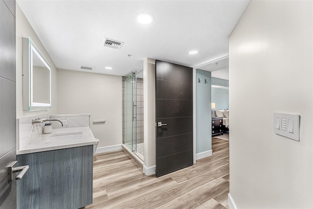 bathroom featuring a shower with shower door, vanity, and hardwood / wood-style floors