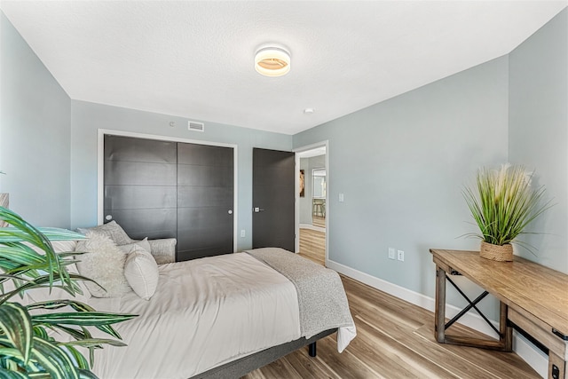 bedroom featuring hardwood / wood-style floors and a closet