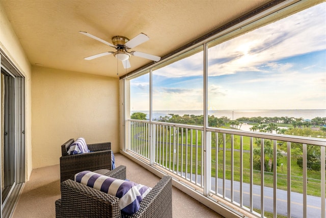 balcony featuring ceiling fan and a water view