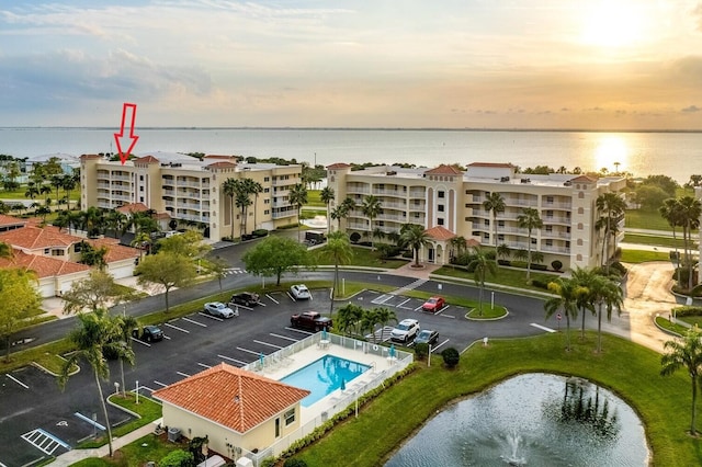 aerial view at dusk featuring a water view