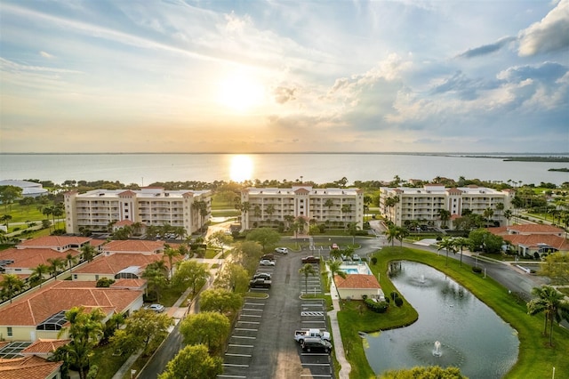 aerial view at dusk featuring a water view