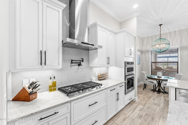 kitchen with white cabinetry, light stone countertops, wall chimney range hood, and appliances with stainless steel finishes