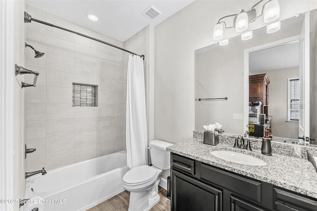 full bathroom featuring hardwood / wood-style floors, toilet, vanity, and shower / bath combination with curtain