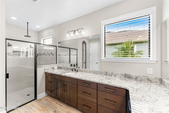 bathroom with hardwood / wood-style floors, an enclosed shower, and vanity