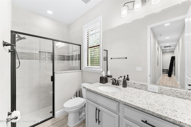 bathroom featuring vanity, toilet, hardwood / wood-style floors, and an enclosed shower