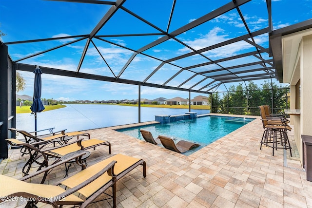 view of pool featuring glass enclosure, pool water feature, a patio area, and a water view