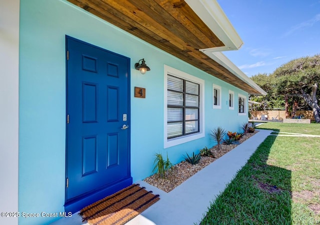 doorway to property with a yard