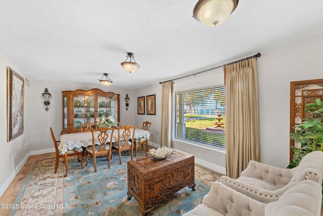 dining space featuring baseboards and wood finished floors