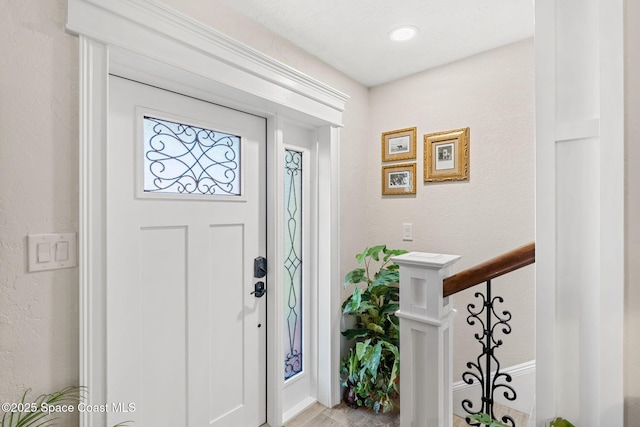 foyer with stairway and a textured wall