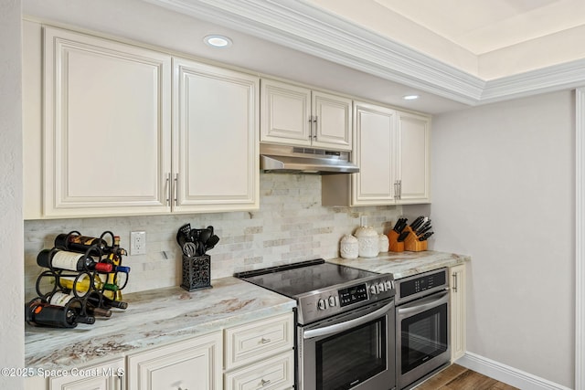 kitchen featuring stainless steel appliances, decorative backsplash, light stone countertops, under cabinet range hood, and baseboards