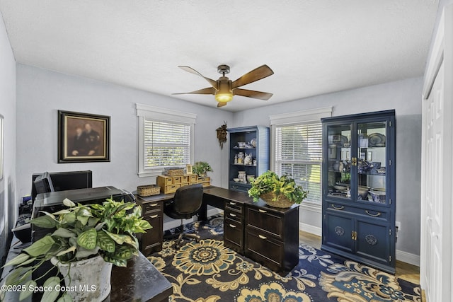 office area featuring baseboards and a ceiling fan