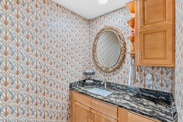 bathroom with wallpapered walls and vanity