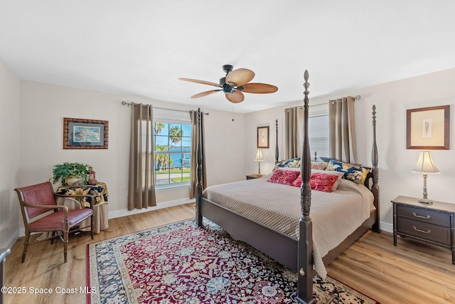 bedroom with light wood-style floors, baseboards, and a ceiling fan