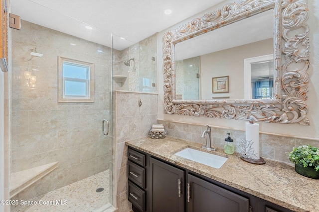 full bath with a shower stall and vanity