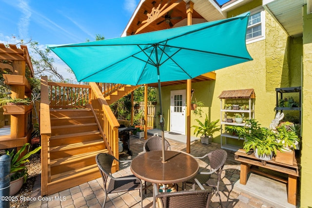 view of patio with ceiling fan, stairs, and outdoor dining space