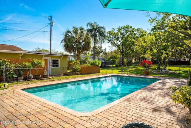 view of swimming pool featuring a patio area, a fenced in pool, fence, and a lawn