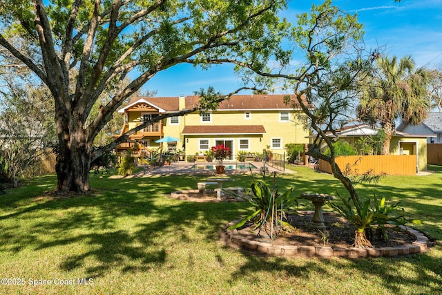 back of house with a patio, a fenced backyard, a chimney, a yard, and stucco siding