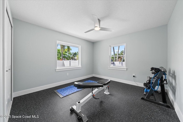 workout room featuring a textured ceiling, ceiling fan, and a wealth of natural light