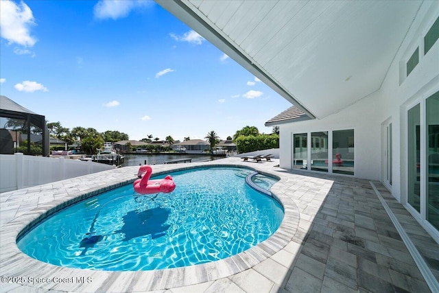 view of pool with a patio area and a water view