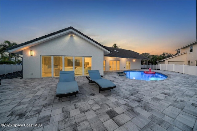 pool at dusk featuring a patio