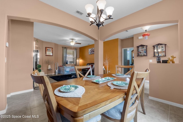 dining area featuring tile patterned flooring and ceiling fan with notable chandelier