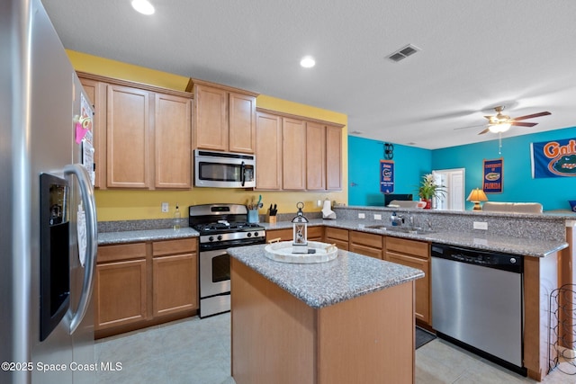 kitchen with sink, ceiling fan, kitchen peninsula, a kitchen island, and appliances with stainless steel finishes