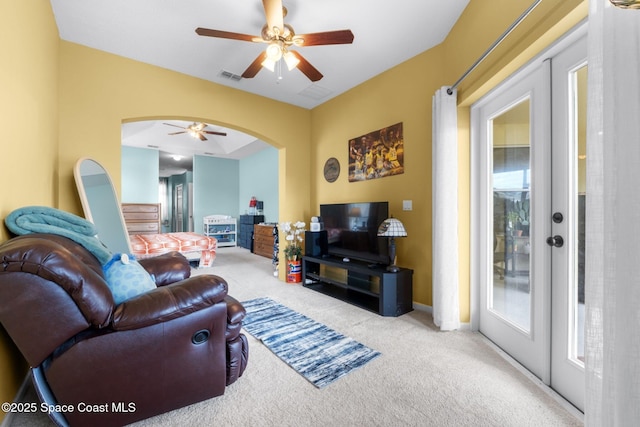 living room featuring ceiling fan, french doors, and light carpet