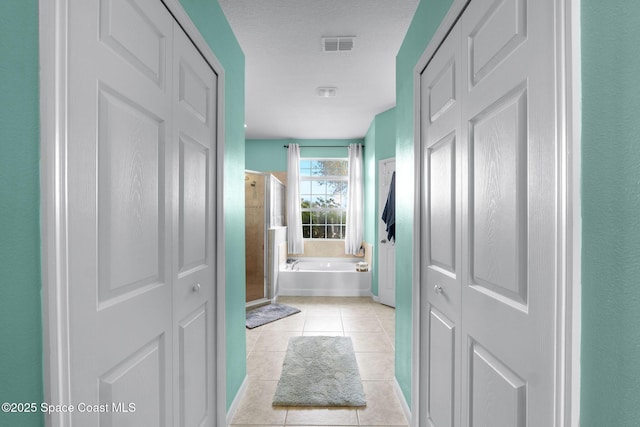 bathroom featuring a textured ceiling, tile patterned floors, and shower with separate bathtub