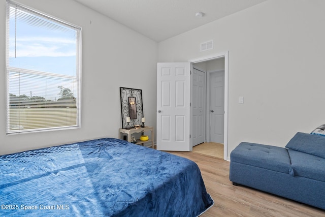 bedroom featuring light hardwood / wood-style floors and vaulted ceiling