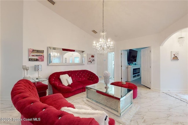 living area featuring marble finish floor, visible vents, baseboards, a chandelier, and arched walkways