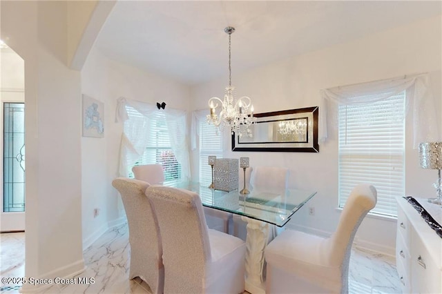 dining area with baseboards, marble finish floor, and a chandelier