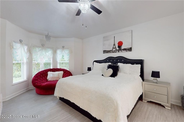 bedroom featuring light wood-style floors, baseboards, and a ceiling fan