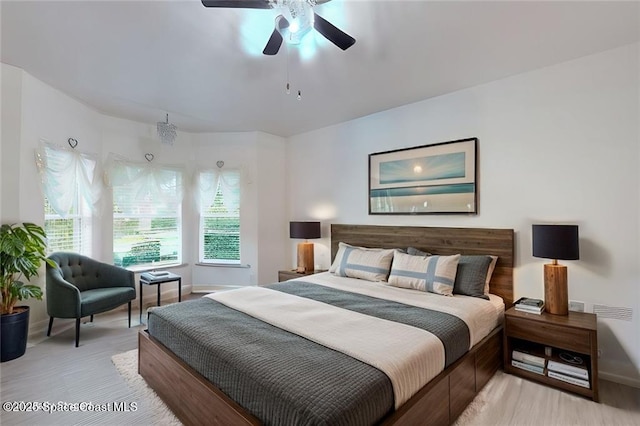 bedroom with light wood-style flooring, baseboards, and ceiling fan