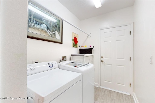 washroom featuring laundry area, light wood-style flooring, and washer and dryer