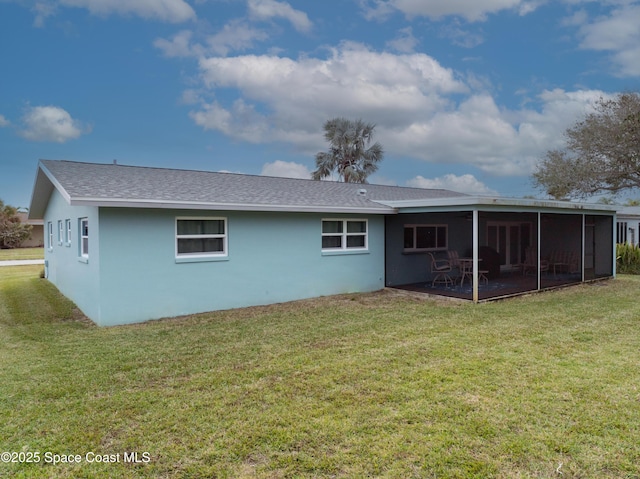 rear view of house with a yard and a sunroom