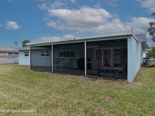 back of house with a yard and a sunroom