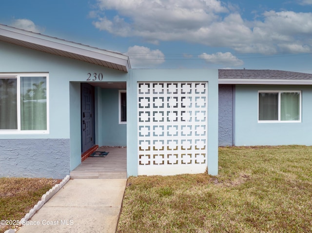 view of exterior entry with a yard