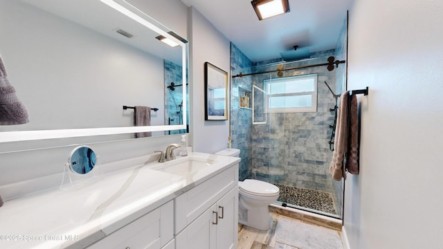 bathroom with walk in shower, vanity, toilet, and hardwood / wood-style floors