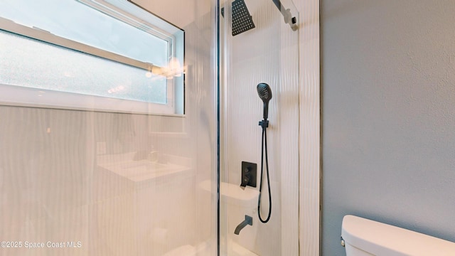 bathroom with toilet and a shower with door