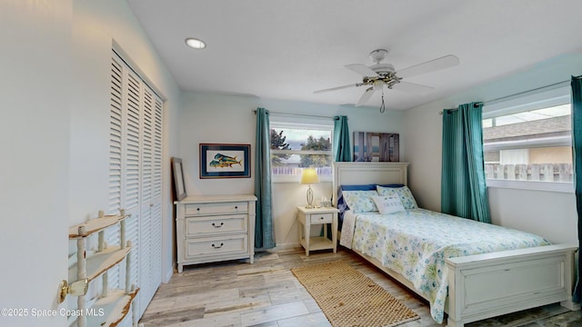 bedroom with ceiling fan, a closet, and light wood-type flooring