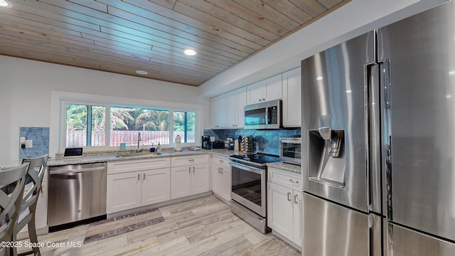 kitchen with sink, white cabinetry, stainless steel appliances, light stone counters, and wooden ceiling