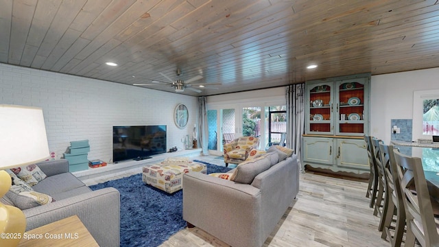 living room featuring ceiling fan, brick wall, light hardwood / wood-style floors, and wooden ceiling