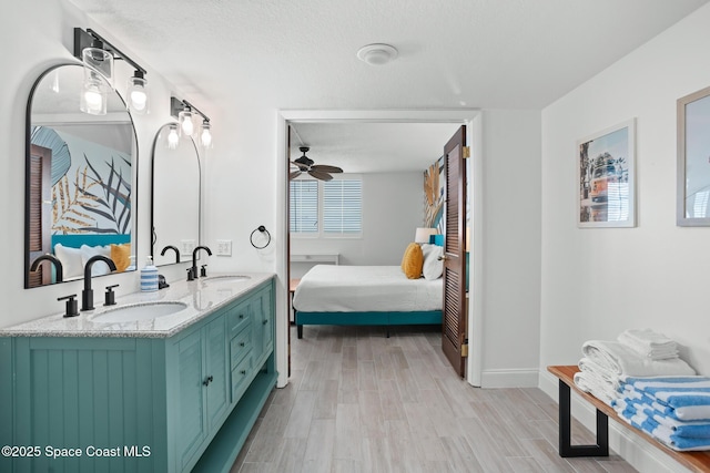 bathroom with a textured ceiling, ceiling fan, vanity, and hardwood / wood-style floors