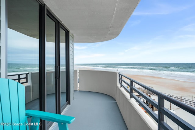 balcony featuring a beach view and a water view